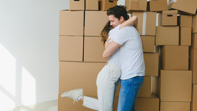 Un couple qui se serre devant des boites de déménagement